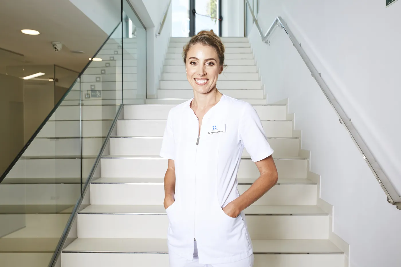 Medarbejder i hvid uniform på trappen